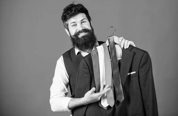 Perfect necktie. Shopping concept. Shop assistant or personal stylist service. Stylist advice. Matching necktie with outfit. Man bearded hipster hold neckties and formal suit. Guy choosing necktie