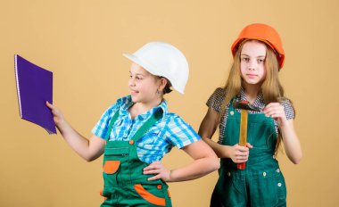 küçük kızlar atölyede birlikte tamir. Foreman müfettişi. Onarım. Tablet ve çekiçle miğferli küçük çocuklar. İşçi bayramı. 1 mayıs. mutlu çocuklar. Gelecekteki kariyeri. Güven ve uzmanlık dolu