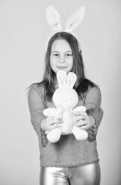 Gelukkige jeugd. Pasen-activiteiten voor kinderen. Vakantie bunny meisje met lange bunny oren. Kind schattige bunny kostuum. Kind houdt inschrijving zachte konijn speeltje. Pasen dag komen. Pasen vieren — Stockfoto