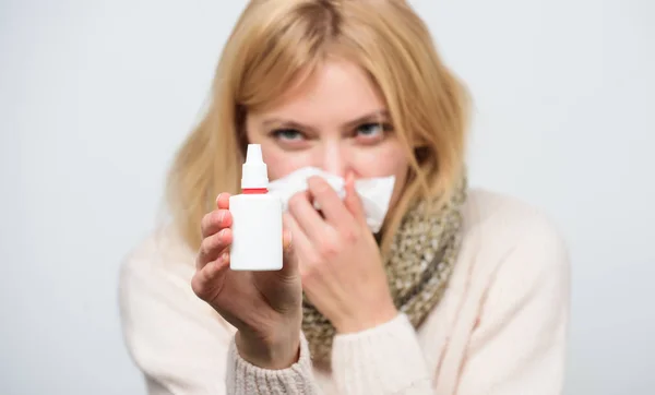 Relieving itchy nose. Cute woman nursing nasal cold or allergy. Sick woman spraying medication into nose. Treating common cold or allergic rhinitis. Unhealthy girl with runny nose using nasal spray — Stock Photo, Image