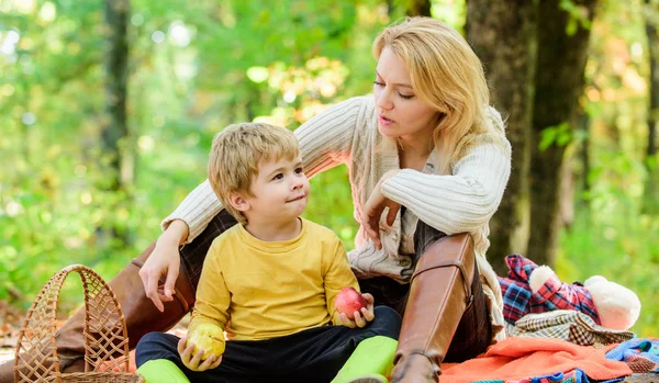 Natural beauty. Happy son with mother relax in autumn forest. Family picnic. Mothers day. Spring mood. Happy family day. Sunny weather. Healthy food. Mother love her small boy child