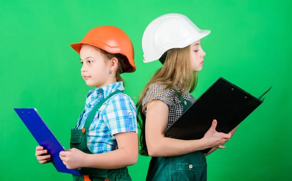 school project. small girls repairing together in workshop. Labor day. 1 may. Little kids in helmet with tablet. Foreman inspector. Repair. school project concept. children work for school project