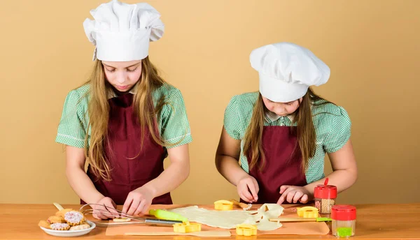 The home of high class baking. Small children taking cooking class together. Little girls preparing cookies in cooking class. Master class in pastry baking