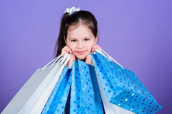 Ventas y descuentos. Moda infantil. asistente de tienda con paquete. oferta especial. Ahorro de compra vacaciones. Niña pequeña con bolsas de compras. Feliz niña. Niña con regalos. Viernes negro. venta viernes negro — Foto de Stock