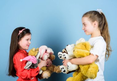 Birlikte dinleniyoruz. Anaokulundaki oyun parkında. Küçük kız kardeşler oyun odasında oyun oynuyorlar. Yumuşak ayı oyuncakları olan küçük kızlar. Mutlu çocukluk. El yapımı. Dikiş ve dikişler. Oyuncakçı. çocuk günü