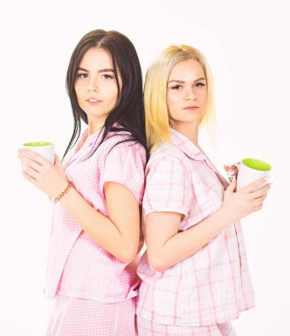 Sabah kahve kavramı. Sarışın ve esmer yüzündeki uykulu kupaları kahve ile tutar. Kız ya da arkadaşlarım pijama. Beyaz arka plan üzerinde izole içme çay veya kahve sabah, kızlar