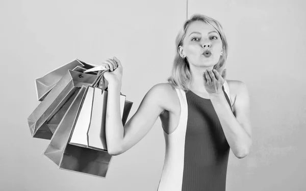 Compra todo lo que quieras. Chica satisfecha con las compras. Consejos para comprar ventas con éxito. Chica disfrutar de las compras o acaba de recibir regalos de cumpleaños. Mujer vestido rojo mantenga racimo bolsas de compras fondo rosa azul —  Fotos de Stock