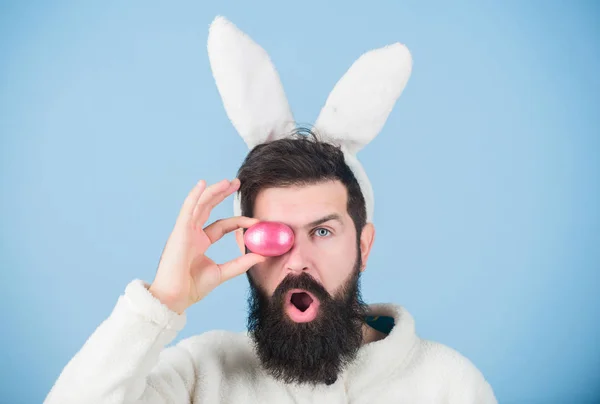 Coelho engraçado com barba e bigode segurar ovo rosa. Homem barbudo usa orelhas de coelho bobas. Conceito de símbolo de Páscoa. Meu precioso. Hipster bonito coelho orelhas longas fundo azul. Coelhinho da Páscoa. A divertir-se — Fotografia de Stock