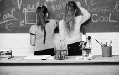 Kız sınıf arkadaşları Kimya çalışmasında. Mikroskop ve test tüpleri masada. Kimyasal reaksiyonlar. Kimya Eğitimi ilginç olun. Kimya dersi için kara tahta 'da öğrenci. Eğitim deneyi konsepti