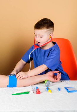 Kan basıncını ölçmek. Tıbbi muayene. Tıp eğitimi. Çocuk sevimli çocuk gelecek doktor kariyer. Sağlık. Çocuk küçük doktor steteskop ve tıbbi aletlerle masaya otursun. Tıp kavramı