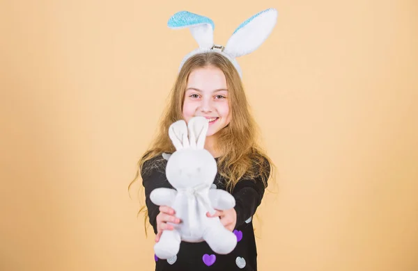 Hoffnung und Unschuld. glückliches Kind, das in Osterhasenmanier lächelt. Osterhase bringt dem guten Kind Geschenke. Mädchen mit weicher Hasenpuppe am Ostertag. Kleines Kind mit niedlichem Kaninchen-Spielzeug — Stockfoto