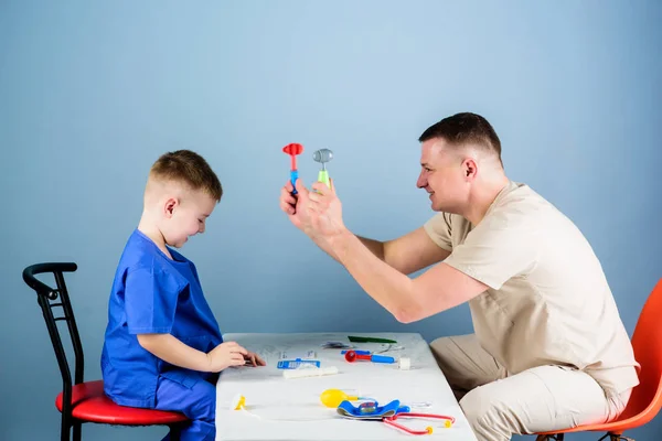 Medical examination. Medical service. Man doctor sit table medical tools examining little boy patient. Pediatrician concept. Health care. Child care. Careful pediatrician check health of kid — Stock Photo, Image