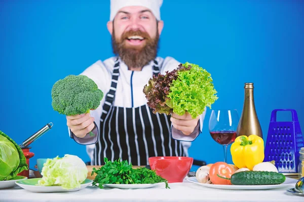 Hälsa och bantning. Man kock hatt förkläde hålla broccoli och sallad. Vegan recept koncept. Köpa färska grönsaker livsmedelsbutik. Vegan restaurang. Hipster kökschefen vegan café. Jag väljer vegansk livsstil — Stockfoto