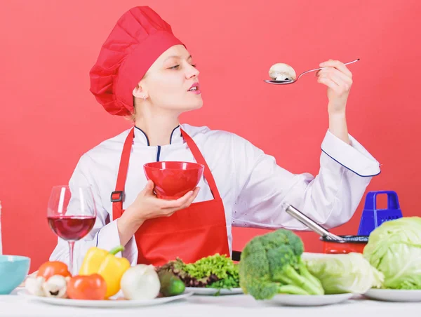 Dieet concept. Eet gezond. Gezonde rantsoen. Meisje slijtage hoed en schort proberen paddestoel smaak. Professionele chef-kok vrouw houd lepel met rauwe paddestoel. Gezonde vegetarische en veganistische recepten. Gezonde rauwkost — Stockfoto