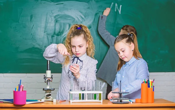 Школьное образование. Школьницы учатся. Дети в классе с микроскопом и пробирками. Изучить биологические молекулы. Концепция будущих технологий и науки. Дети изучают биологию или химию в школе — стоковое фото