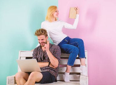 Çift farklı ilgi alanları ile birlikte vakit geçirmek. İlgi odağı. Kız ve adam entelektüel faaliyet baktılar. Dizüstü bilgisayar ve kitap hevesli entelektüel faaliyet kadınla adam