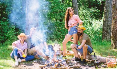 Arkadaşlar çiftler tatil veya hafta sonu orman tadını çıkarın. Yaz tatili. Şirket yetişkin arkadaş kamp ateşi rahatlatıcı. Arkadaşlar boş zaman hafta sonu Orman Doğa arka plan harcamak. Kamp ateşi yanında hoş hafta sonu