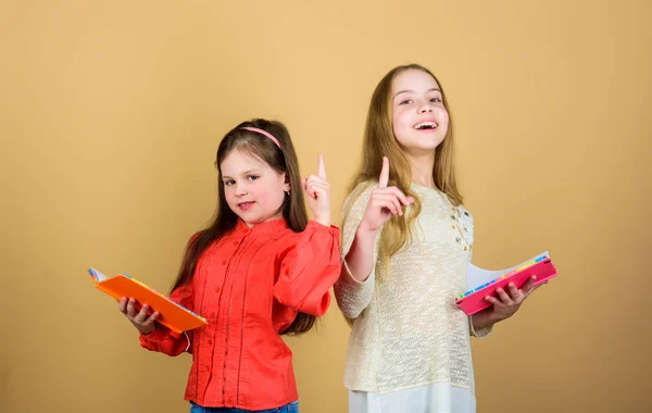 Muito ocupado. estudantes lendo um livro. Projecto escolar. meninas pequenas com cadernos. Amizade e irmandade. crianças pequenas felizes prontas para a lição da escola. livros para escrever. De volta à escola — Fotografia de Stock