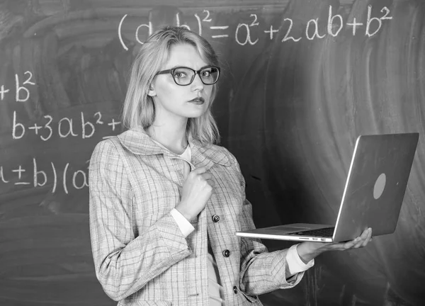 Teacher elegant lady with modern laptop surfing internet chalkboard background. Distance education concept. Woman teacher wear eyeglasses holds laptop surfing internet. School innovation concept — Stock Photo, Image