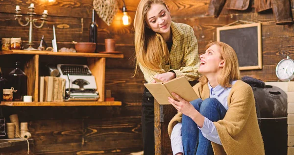 Girls reading together, family leisure activity. Teenager studying literature with her mom, home education concept. Mother and daughter looking at each other and laughing about funny scene in book