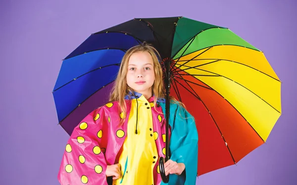 Gli accessori impermeabili rendono la giornata piovosa allegra e piacevole. Ragazza felice tenere colorato ombrello indossare mantello impermeabile. Accessori impermeabili per bambini. Godetevi il tempo piovoso con indumenti adeguati — Foto Stock