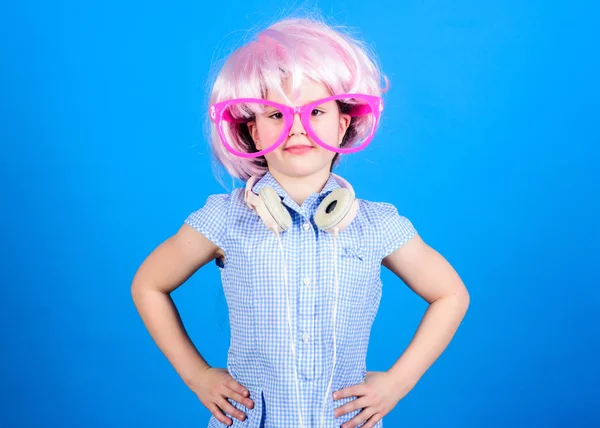 Siendo un niño fiestero. Niño pequeño con peluca de pelo y gafas de lujo con auriculares. Adorable niño disfruta escuchando música. Lindo niño pequeño con aspecto de fiesta — Foto de Stock