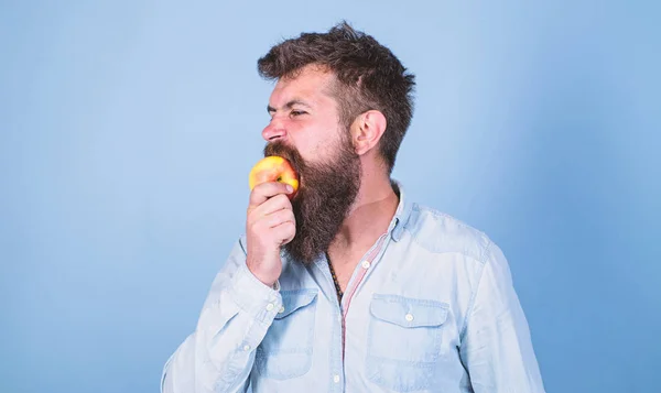 Man diet nutrition eats fruit. Man handsome hipster with long beard eating apple. Hipster hungry bites juicy ripe apple. I love apples Fruit healthy snack always good idea. Healthy nutrition concept