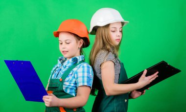 Foreman müfettişi. Onarım. takım çalışması iş ... Tabletli kasklı küçük çocuklar. İşçi bayramı. 1 mayıs. küçük kızlar atölyede birlikte tamir. Evinizi uzmanlara emanet edin