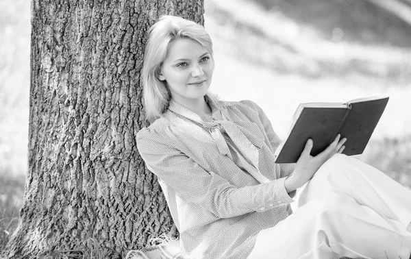 Auto-amélioration féminine. Fille s'appuyer sur l'arbre tout en se détendre dans le parc assis herbe. Livre d'auto-amélioration. Femme d'affaires trouver minute pour lire livre améliorer ses connaissances. Auto-amélioration et concept d'éducation — Photo