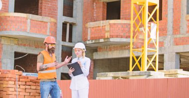 Kadın mühendis ve Oluşturucu inşaat alanında iletişim. İnşaat ekibi iletişim kavramı. İnşaat istemcileri ve inşaat sektöründe katılımcılar arasındaki ilişkiler. Planı tartışıyor