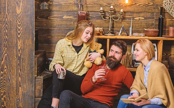 Keluarga kutu buku membaca bersama di sofa. Orangtua dan putri remaja menghabiskan Natal di pedesaan. Pria berjenggot minum anggur mulled pada malam musim dingin. Gadis penasaran melihat ayahnya. — Stok Foto