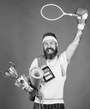 En sevdiğim spor seçin. Spor kavram. Başarı için yolda. Spor salonu ürün yelpazesine sahip. Adam atlet tutun spor ekipmanları ip atlama fitness mat boks eldiveni genişletici raket ve altın kadehi sakallı