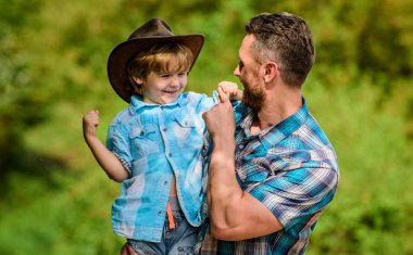 Küçük çocuk ve baba doğa arka plan. Macera ruhu. Babam gibi güçlü. Güç baba olmak. Çocuk eğleniyor kovboy baba. Rustik bir aile. Büyüyen sevimli kovboy. Bahçede küçük yardımcı