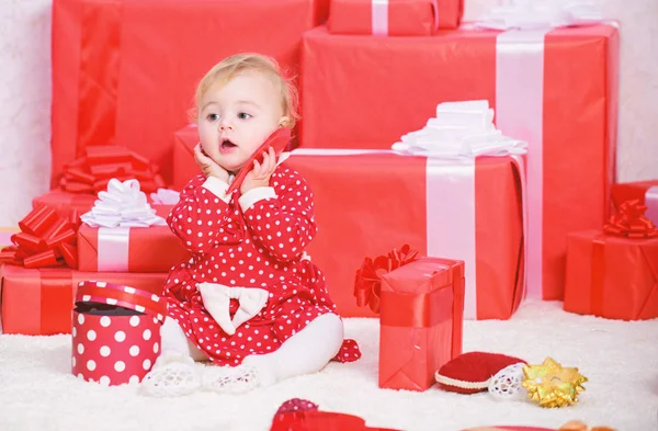 Ділитися радістю з дитиною перше Різдво з родиною. Маленька дівчинка грає біля купи подарункових коробок. Подарунки для дитини перше Різдво. Святкуй перше Різдво. Дитяче перше Різдво одного разу в житті — стокове фото