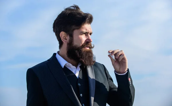 Cool handsome smoking. brutal caucasian hipster with moustache. Bearded man smoking cigarette. smoke. Mature hipster with beard. Future success. Male formal fashion. Businessman against the sky