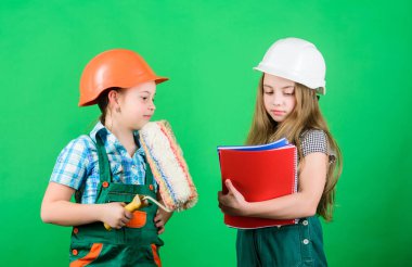 İşçi bayramı. 1 mayıs. Foreman müfettişi. Onarım. okul projesi. küçük kızlar atölyede birlikte tamir. Tablet ve rulo ile kask küçük çocuklar. İşçi Bayramı konsepti. Çocuklar için çalışma günü