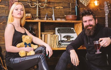 Çift gamekeepers evde, ahşap iç arka plan romantik akşamın. İki aşık oyuncak ayı ve mulled şarap. Rahatlatıcı kavramı. Kız ve adam mutlu yüzler üzerinde sıcak atmosferde dinlenmek