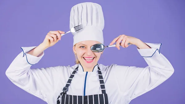 Appetite and taste. Traditional culinary. Professional cook of culinary school. Culinary arts academy. Culinary school concept. Woman professional chef hold utensil spoon fork having fun. Time to eat