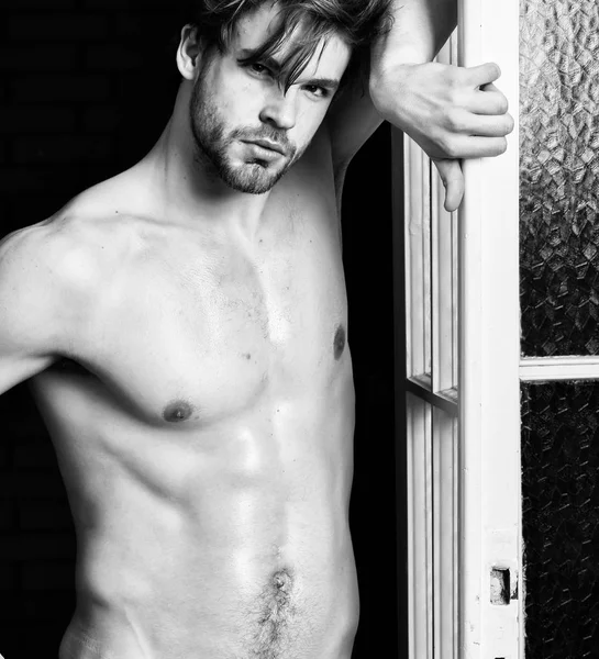 Man confident lover near door. Sexy attractive macho tousled hair coming out through bedroom door. Sexy bachelor lover concept. Guy attractive lover posing seductive. Seductive lover full of desire