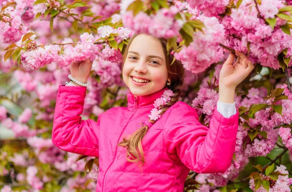 Różowy jest moim ulubionym. Dziewczynka lubi wiosnę. Dzieciak na różowych kwiatach tła drzewa sakura. Dzieciak cieszący się różowym kwiatem wiśni. Delikatny kwiat. Różowy to najbardziej dziewczęcy kolor. Jasne i żywe — Zdjęcie stockowe