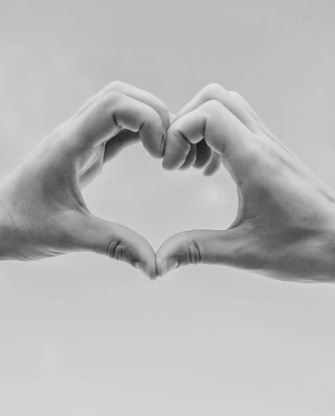 Kéz össze a szív alakú kék ég háttér. Szerelmi szimbólum fogalom. Kézzel szív gesztus formák alakú ujját. Férfi kezét a szív alakú megfelelő kézmozdulat-szimbólum a szerelem és romantika — Stock Fotó