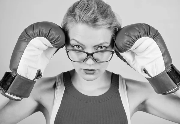 A huge sense of self confidence. Sportswoman with nerdy look. Pretty woman in glasses and boxing gloves. Cute boxer girl. Athletic woman in sports wear. Boxing makes her super fit