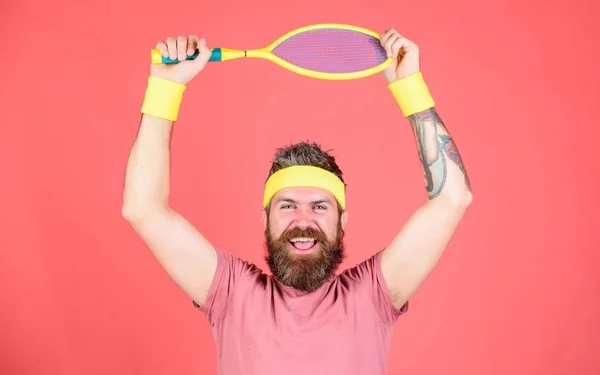 Jugador de tenis de moda vintage. Tenis deporte y entretenimiento. Hombre barbudo hipster llevar traje deportivo. Concéntrate en el objetivo. Logro deportivo. Atleta hipster mantenga raqueta de tenis en la mano fondo rojo — Foto de Stock