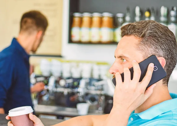 Homem segura xícara de bebida enquanto tem conversa móvel. Café para ir opção útil para pessoas ocupadas. Liga ao amigo para beberem juntos. Guy ocupado falar telefone enquanto relaxa coffee break. Pronto para te ouvir. — Fotografia de Stock