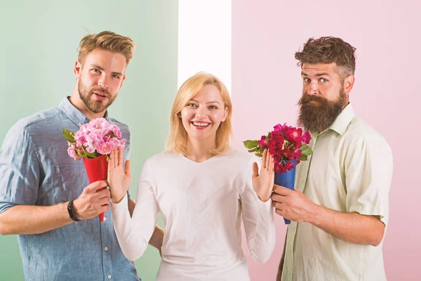 Men competitors with bouquets flowers try conquer girl. Girl smiling reject gifts. Out of relations. Feminism concept. Woman smiling reject both male partners. Girl popular receive lot men attention — Stock Photo, Image