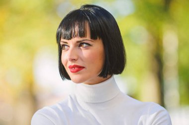 Mükemmel makyaj esmer bayan için. Kadın kırmızı dudaklar makyaj defocused yüz arka plan ile yakın kadar gizemli. Moda ve güzellik kavramı. Makyaj parlak vurgu dudaklarında. Kırmızı ruj makyaj ona uygun