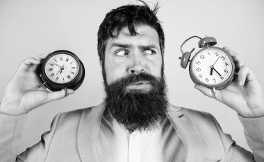 Bir adam tıraşsız şaşkın yüz zaman değişen sorunlar mı yaşıyorsunuz. Değişen zaman dilimleri sağlık etkiler. Saat dilimi. Saat pislik sağlığınız ile değişen yok. Adam hipster tutun iki farklı saatler sakallı