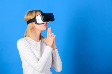 3D gözlük kullanan bir kadın heyecanlı. Sanal gerçeklik kulaklığı kullanan genç bir kadın. Sanal gerçeklik deneyimi sırasında genç bir kadın havaya dokunuyor. VR resmi.