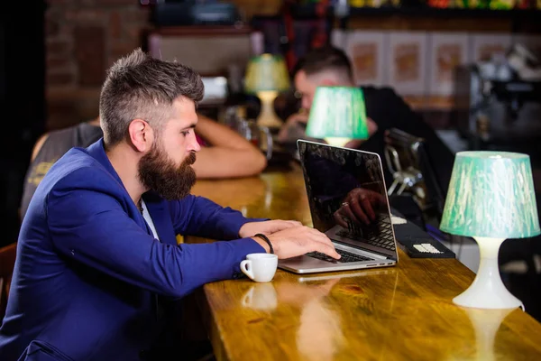 Hipster freelance travailler en ligne boire du café. Concept de pause café. Homme barbu homme d'affaires assis comptoir de bar avec ordinateur portable et tasse de café. Créer un blog web de contenu. Gestionnaire créer poste profiter du café — Photo