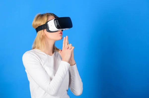 Egy nő izgatott 3D-s szemüveggel. Egy fiatal nő virtuális valóság fülhallgatót használ. Lenyűgöző fiatal nő megérintette a levegőt a VR élmény alatt. VR-kép. — Stock Fotó